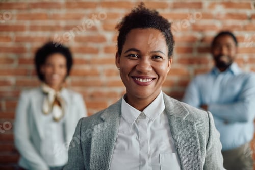 Preview: Happy African American female leader and her business team in the office.