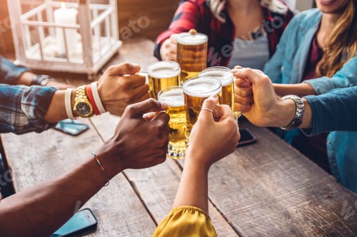 Preview: Happy diverse young people celebrating together toasting beers