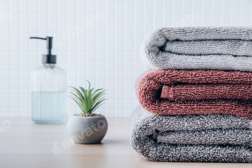 Preview: Towels. Clean fresh fluffy towels and bath accessories on table in bathroom