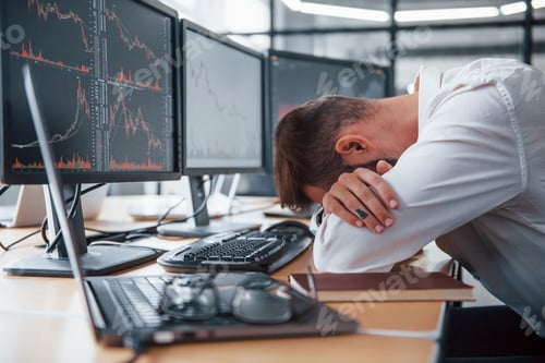 Preview: Tired businessman sleeping on the workplace by leaning on the table with multiple screens on it