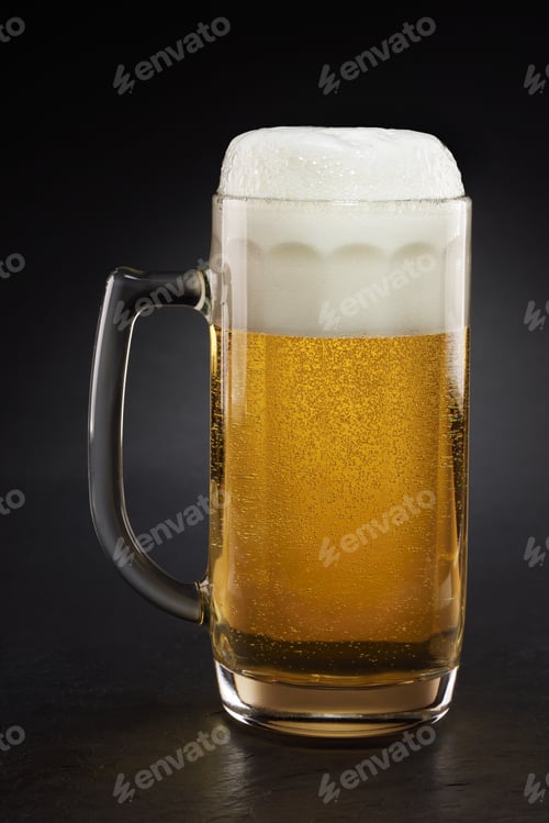 Preview: Stein with fresh beer with cap of foam on a black.