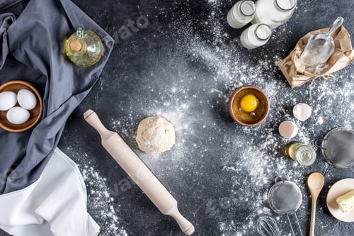Preview: top view of raw dough, baking ingredients and cutlery on marble surface
