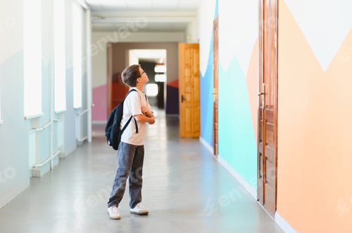 Preview: Curious pupil looking up in school hallway contemplating new school year