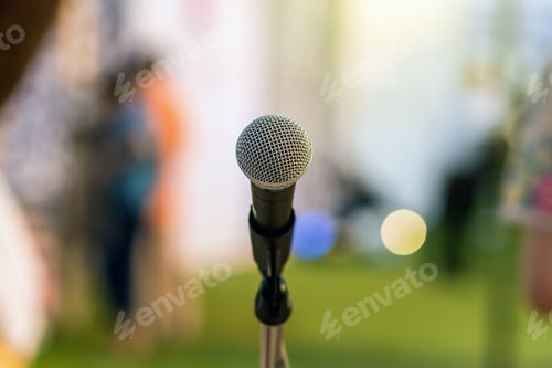 Preview: Microphone on the stage over the Abstract blurred photo of green grass