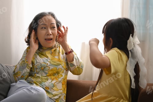 Preview: Mature grandmother covering her ears, having problem with noisy naughty little child screaming.