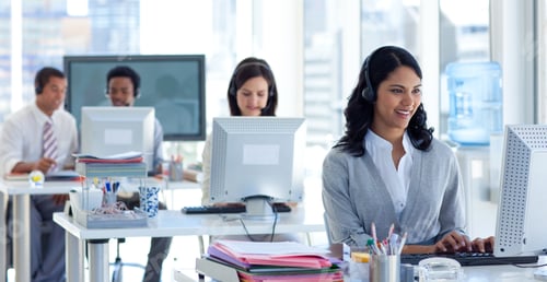 Preview: Ethnic Businesswoman With A Headset On In A Call Center With Her Colleagues