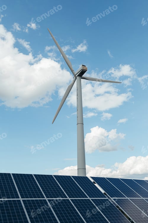 Preview: Wind Turbine and Solar panels of electric station in bottom. Day with blue cloudy sky