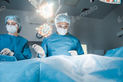 Preview: nurse and surgeon in uniforms and medical masks doing operation