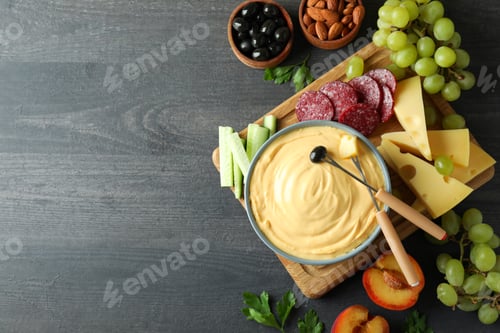 Preview: Concept of delicious food with fondue on dark wooden table