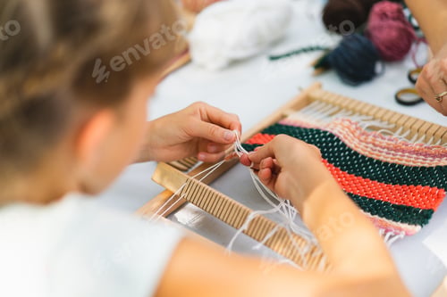 Preview: Girl weaving small rug with pattern at masterclass on weaving.