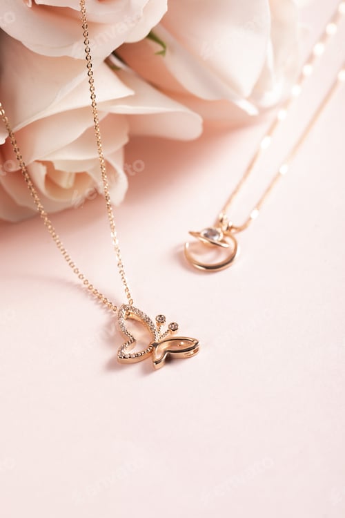 Preview: Vertical selective focus closeup of gold necklaces on a rosy pink background