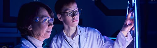 Preview: young intern operating experimental equipment in neon-lit discovery center of future