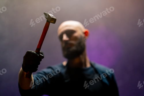 Preview: bald brazen robber with a beard holding a hammer during robbery attack crimes threats