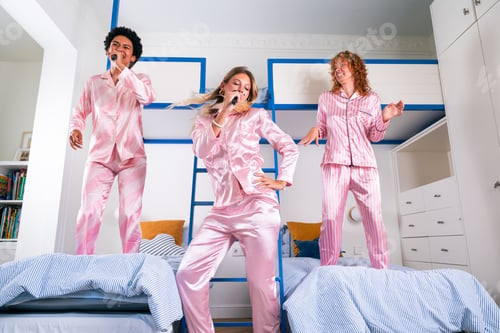 Preview: Multiethnic group of young female friends having pajamas party at home