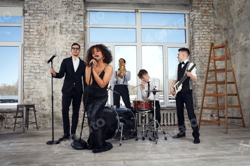 Preview: Repetition of multi ethnic jazz band in loft. Bass guitar player, electric guitar player