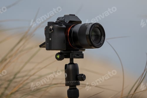 Preview: Closeup shot of a mirrorless camera on a tripod at the beach