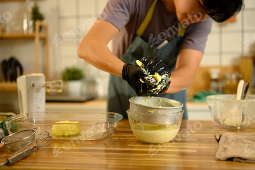 Preview: Gloved hands squeezing creamy butter over bowl, releasing fresh buttermilk
