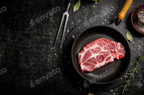 Preview: Raw pork steak in a frying pan.