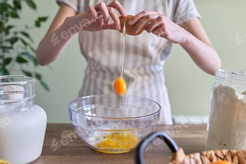 Preview: Close-up of breaking an egg in bowl, preparing dough for pancakes