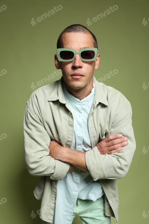 Preview: Fashionable portrait of handsome man in stylish outfit on green background