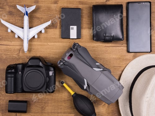 Preview: Flat lay top view of traveler accessories on white wooden background.