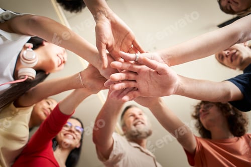 Preview: bottom view. group of happy young people making a tower out of their hands .