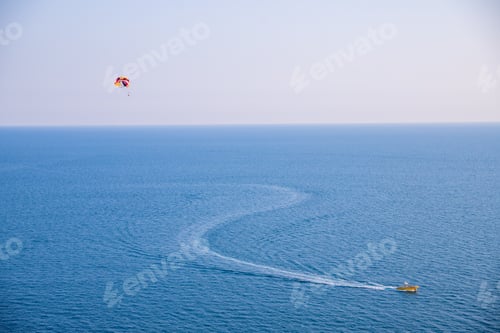 Preview: Parasailing on the sea, speed boat and couple on parachute in blue sky