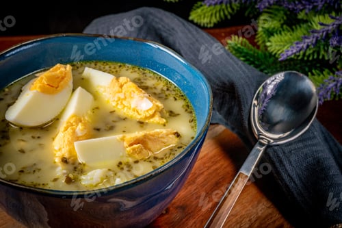 Preview: A bowl of soup sorrel with rice and boiled egg.