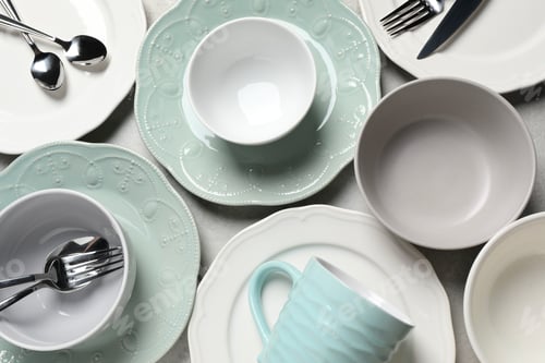 Preview: Beautiful ceramic dishware, cup and cutlery on light grey table, flat lay