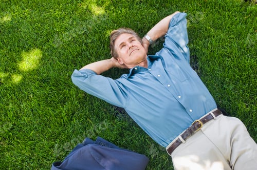 Preview: Businessman relaxing on grass