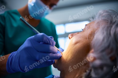 Preview: Close up of senior woman having her teeth examined by a dentist.