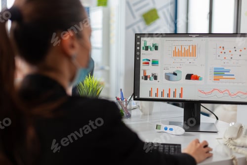 Preview: Businesswman analysing financial statistics in new normal offfice