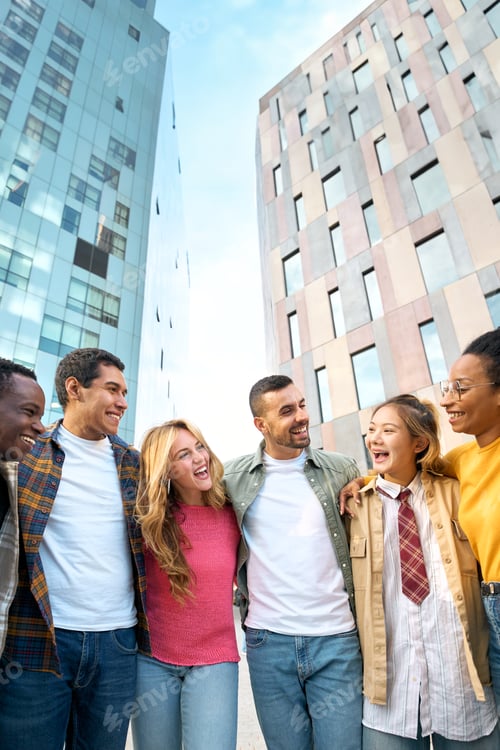 Preview: Happy group of young European student friends having fun together and hugging outdoors