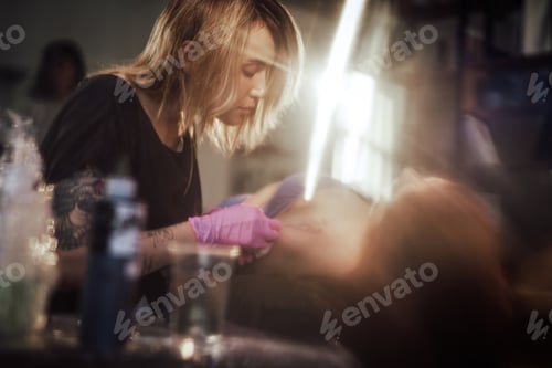 Preview: Tattoo master caring and using doily to clean shoulder