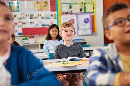Preview: Happy smiling schoolboy in classroom