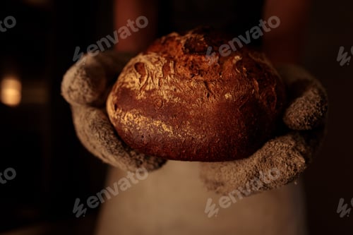 Preview: a person wearing gloves holds a loaf of bread in their hands