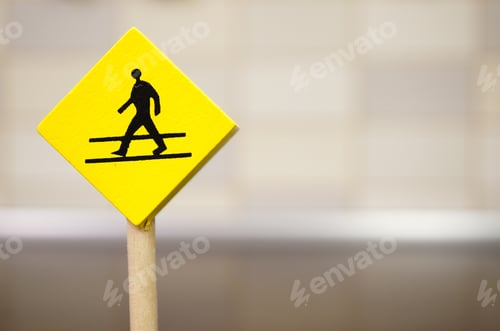 Preview: Miniature illustration of a walking pedestrian sign on a yellow sticker with blurred background