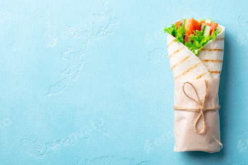Preview: Wrap Sandwich, Roll With Fish Salmon and Vegetables. Blue Background. Copy Space. Top view.