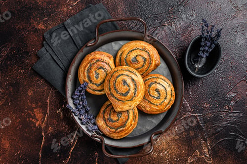 Preview: Sweet twisted Bun with poppy seeds and lavender. Dark background. Top view