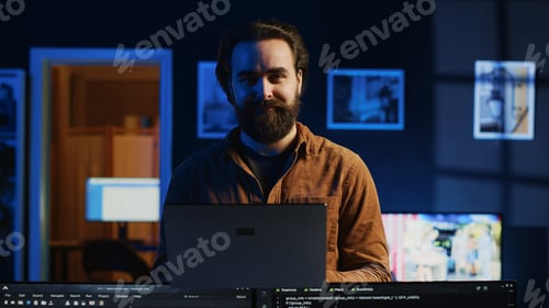 Preview: Portrait of smiling developer writing complex binary code scripts on laptop