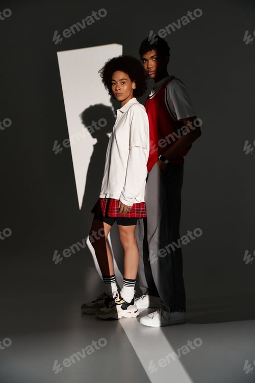 Preview: Young couple embraces love and style in a chic studio setting under dramatic lighting