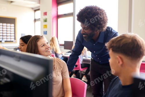 Preview: Male Teacher Helping Teenage Female High School Student Working In Computer Class