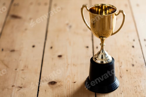 Preview: Gold winners trophy on a wooden background