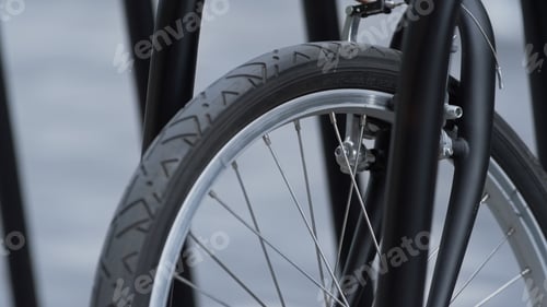 Preview: Closeup front bicycle wheel standing on shared parking. Alternative transport.