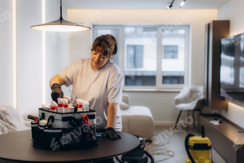 Preview: Professional cleaner selecting cleaning bottles from service bag