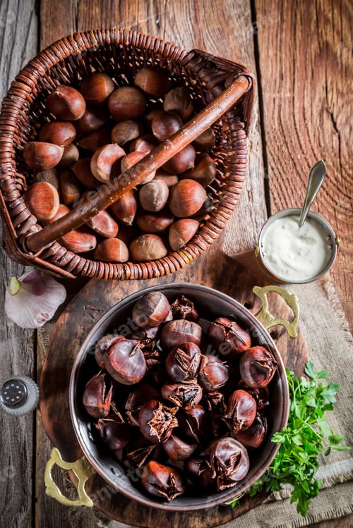 Preview: Closeup of delicious chestnuts with parsley on old wooden table
