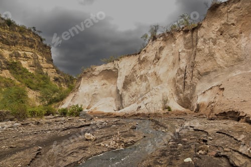 Preview: Rocky valley surrounded by cliffs against the background of the cloudy sky.