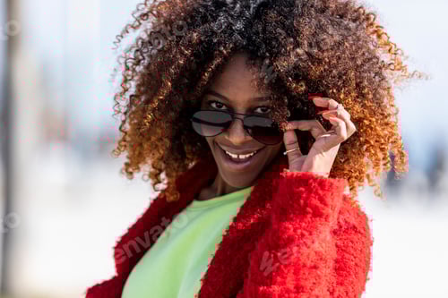 Preview: Portrait of a beautiful afro american woman standing in the street in a sunny day
