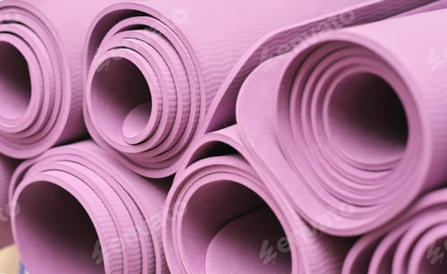 Preview: yoga mats folded on a shelf in fitness club. pilates and stretching equipment