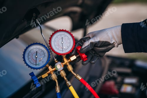 Preview: Close up hand of Mechanics inspect and check the refrigerant and fill the car air conditioner.